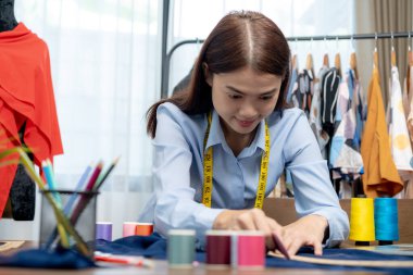 Gururlu ve tutkulu, bayan dükkan sahibi rahat butiğinde terzilik günlerinin tadını çıkarıyor.