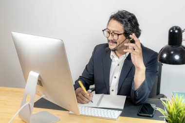 Genç kulaklıklı profesyonel, sanal bir iş toplantısına katılıyor.