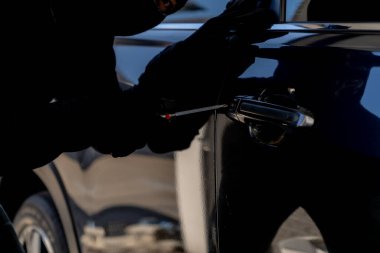 Park halindeki bir araca zorla girmeye teşebbüs, araç hırsızlığı ve güvenlik sorunlarının altını çizmek.