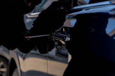 Park halindeki bir araca zorla girmeye teşebbüs, araç hırsızlığı ve güvenlik sorunlarının altını çizmek.