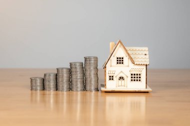 Küçük ev modeli ile el yapımı para toplama, gelecekteki ev alımları için tasarruf simgesi..