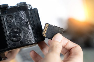 Kameradan hafıza kartının kaldırılması, dijital iş akışını ve görüntü depolamasını sembolize eder.