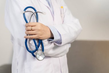 Steteskop tutan bir doktorun yakından görüntüsü, sağlık hizmetlerini, tıbbi profesyonelliği ve hasta bakımını sembolize ediyor..