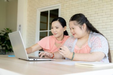Neşeli bir anne, küçük kızına ev ödevlerinde rehberlik eder, evde eğlenceli bir öğrenme anını paylaşır..