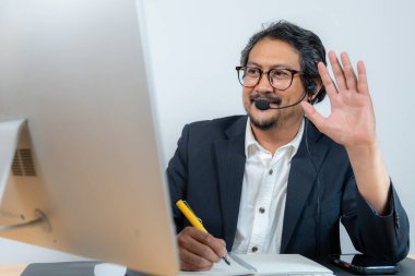 Çevrimiçi video konferansına katılan genç bir işadamı, uzaktan çalışma, dijital iletişim ve modern kurumsal yaşam tarzını temsil ediyor.