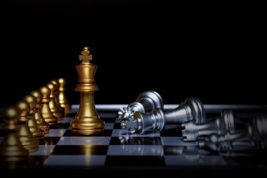Satranç tahtasındaki gümüş satranç taşlarını altın satranç kralı yönetiyor. İş dünyası, başarı, rekabet, takım çalışması ve liderlik kavramı..