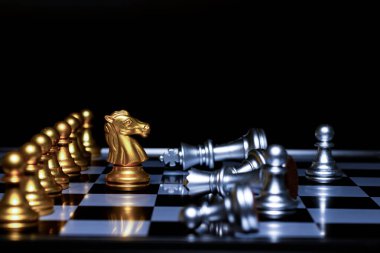 Satranç tahtasındaki gümüş satranç taşlarını altın satranç kralı yönetiyor. İş dünyası, başarı, rekabet, takım çalışması ve liderlik kavramı..