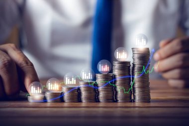 Businessman putting down money, pointing with pen and showing candlestick symbol for investing, finance, saving money, interest rate or dividend investment, business growth concept.