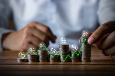 Businessman putting down money, pointing with pen and showing candlestick symbol for investing, finance, saving money, interest rate or dividend investment, business growth concept.