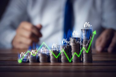 Businessman putting down money, pointing with pen and showing candlestick symbol for investing, finance, saving money, interest rate or dividend investment, business growth concept.