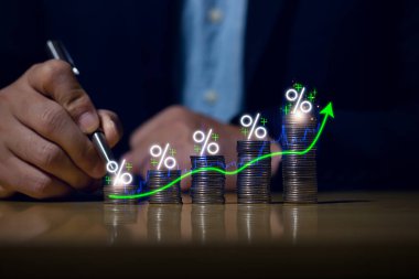 Businessman putting down money, pointing with pen and showing candlestick symbol for investing, finance, saving money, interest rate or dividend investment, business growth concept.