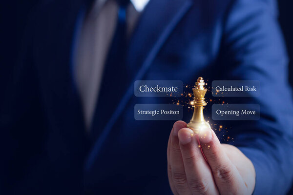Бизнесмен держит золотого шахматиста с ключевыми словами стратегии, символизирующими лидерство, принятие решений и стратегическое бизнес-планирование.