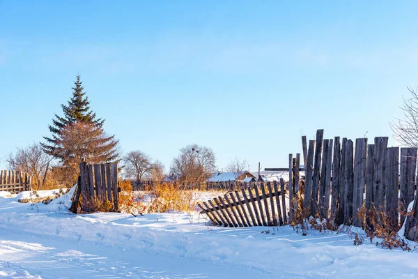 Stock image Village houses and fence covered with snow