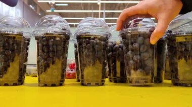 Mans hands choose blueberries in a supermarket. Healthy food, sweet vitamin dessert, berry and fruit sale