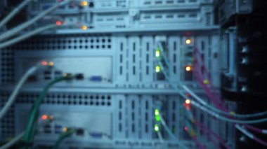 Büyük Veri Merkezi. Fiber optik kablolar ve LED port durumu yanıp sönüyor. Bulanık sunucu rafı