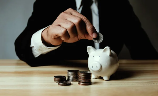 Empresário Segurando Moeda Banco Porquinho Com Pilha Dinheiro — Fotografia de Stock