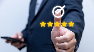 İş adamı, 5 altın yıldız ikonu, garanti konsepti kalite güvencesi ile kalite güvencesi onayı için işaret ya da tik ile baş parmağını gösterdi