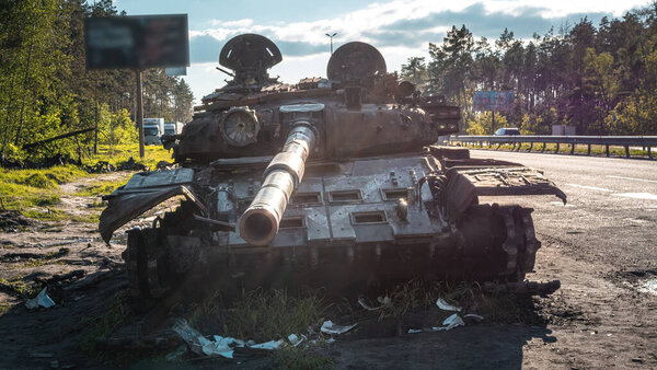 War in Ukraine, Kyiv region, Zhytomyr highway, a broken Russian tank stands near the highway, front view