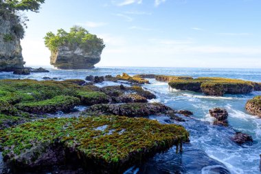 Sawarna Sahili Güzel gökyüzü ve büyük kayalar sahili süslüyor.