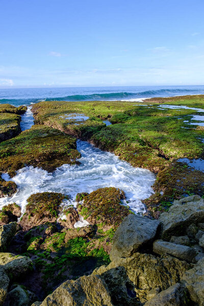 Sawarna Beach Beautiful skies and large rocks adorn the shore.