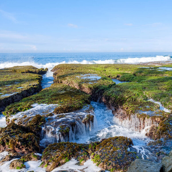 Sawarna Beach Beautiful skies and large rocks adorn the shore.