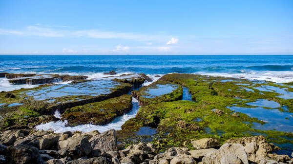 Sawarna Beach Beautiful skies and large rocks adorn the shore.