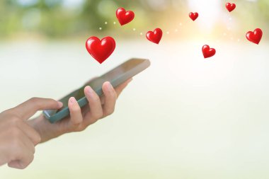 Kadın eli, akıllı telefonu sevgiyle kullanır..