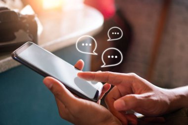 Genç kadın sohbet ve iletişim sosyal medya simgeleri ile akıllı telefon kullanıyor.