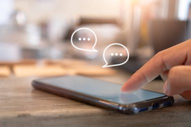 Genç kadın sohbet ve iletişim sosyal medya simgeleri ile akıllı telefon kullanıyor.