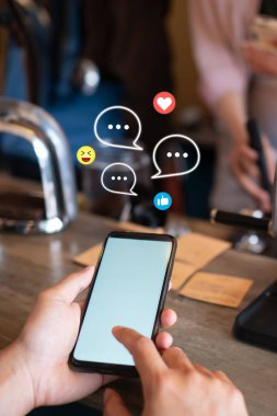 Genç kadın sohbet ve iletişim sosyal medya simgeleri ile akıllı telefon kullanıyor.