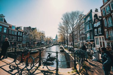8 Nisan 2023: Hollanda, Amsterdam 'da canlı yaşam tarzına sahip kanallar ve sokaklar. Tonu ayarlanmış resim.