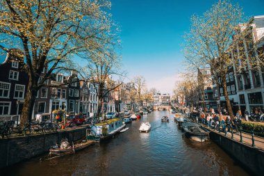 8 Nisan 2023: Hollanda, Amsterdam 'da canlı yaşam tarzına sahip kanallar ve sokaklar. Tonu ayarlanmış resim.