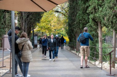 Granada, İspanya: 2022 Kasım: 2022 'de İspanya' nın Granada kentindeki Alhambra Sarayı 'nın girişinde kar kaplı Sierra Nevada Dağları' nın arka planında insanlar.