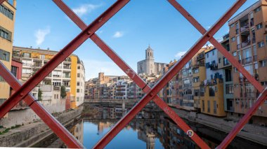 Girona, Spain : january 2023 : Colorful houses reflected in the Onyar river, in Girona, Catalonia, Spain. Church of Sant Feliu and Cathedral of Santa Maria in the background in 2023.