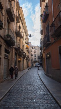 Girona, Spain : 2022 Decemeber 1 : Colorful houses reflected in the Onyar river, in Girona, Catalonia, Spain. Church of Sant Feliu and Cathedral of Santa Mara in the background.