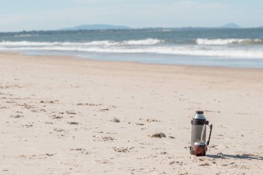 2023 yılında Arjantin, Uruguay, Paraguay ve Brezilya 'da çekilen tipik Mate, plajda termosa eşlik etmiştir..