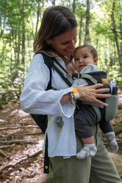 Woman with her 7-month-old baby in the forests of the Pyrenees.