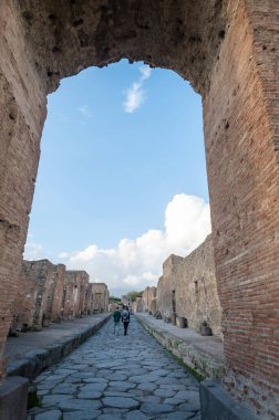 Pompeii, İtalya: 16 Kasım 2023: Antik Pompeii 'de yürüyen insanlar (UNESCO Dünya Mirası Alanı). Kasım 2023 'te Via del Foro' nun taşları..