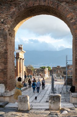 Pompeii, İtalya: 16 Kasım 2023: Antik Pompeii 'de yürüyen insanlar (UNESCO Dünya Mirası Alanı). Kasım 2023 'te Via del Foro' nun taşları..