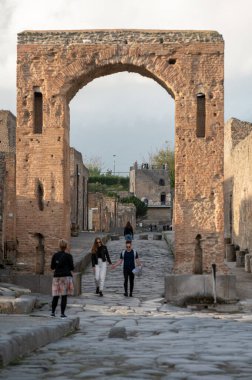 Pompeii, İtalya: 16 Kasım 2023: Antik Pompeii 'de yürüyen insanlar (UNESCO Dünya Mirası Alanı). Kasım 2023 'te Via del Foro' nun taşları..