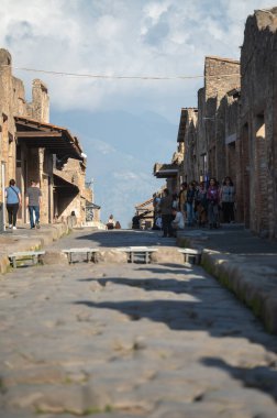 Pompeii, İtalya: 16 Kasım 2023: Antik Pompeii 'de yürüyen insanlar (UNESCO Dünya Mirası Alanı). Kasım 2023 'te Via del Foro' nun taşları..