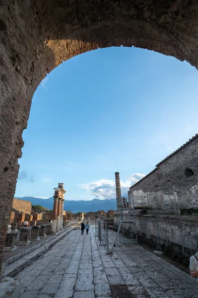 Pompeii, İtalya: 16 Kasım 2023: Antik Pompeii 'de yürüyen insanlar (UNESCO Dünya Mirası Alanı). Kasım 2023 'te Via del Foro' nun taşları..