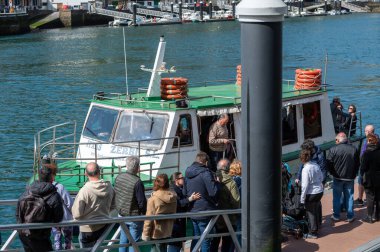 Pasaia, İspanya: 24 Mart 2024: İnsanlar Mart 2024 'te Guipuzcoa ilinin balıkçılık ve turizm kenti Pasaia' da feribota biniyor..