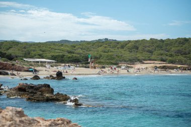 Panorama on the tourist beach of Cala Nova on the island of Ibiza in summer 2024.