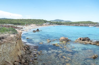 Panorama on the tourist beach of Cala Nova on the island of Ibiza in summer 2024.