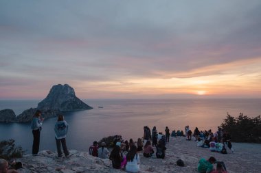 Es Vedra, İbiza, İspanya: 14 Mayıs 2024: 2024 yazında insanlar İbiza 'daki Es Vedra perspektifinde günbatımının keyfini çıkarıyorlar.