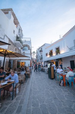 İbiza, İspanya: 16 Mayıs 2024: 2024 yazında insanlar İbiza 'nın eski turizm kasabası Dalt Vila sokaklarında yemek yiyor.