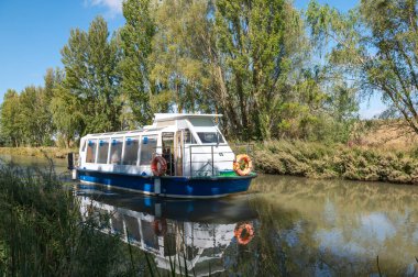 Fromista, İspanya: 21 Ekim 2024: İspanya 'da Catrojeriz' den Fromista 'ya giden Camino de Santiago Route üzerindeki Castilla Kanalı' nda turistler için feribot.