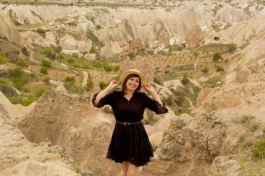 Kapadokya 'da şapkalı ve gözlüklü güzel genç bir kadın, hindi.