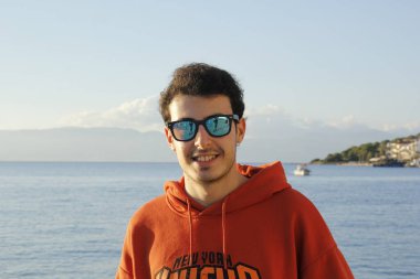 portrait of a handsome man in sunglasses on the beach